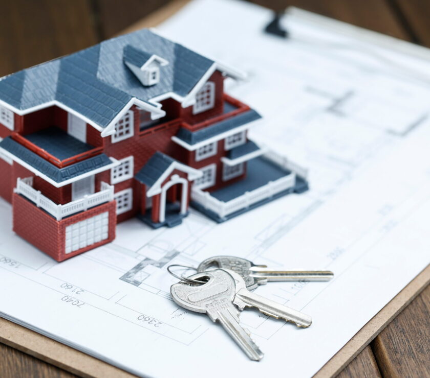 Villa house model, key and drawing on retro desktop (real estate sale concept)